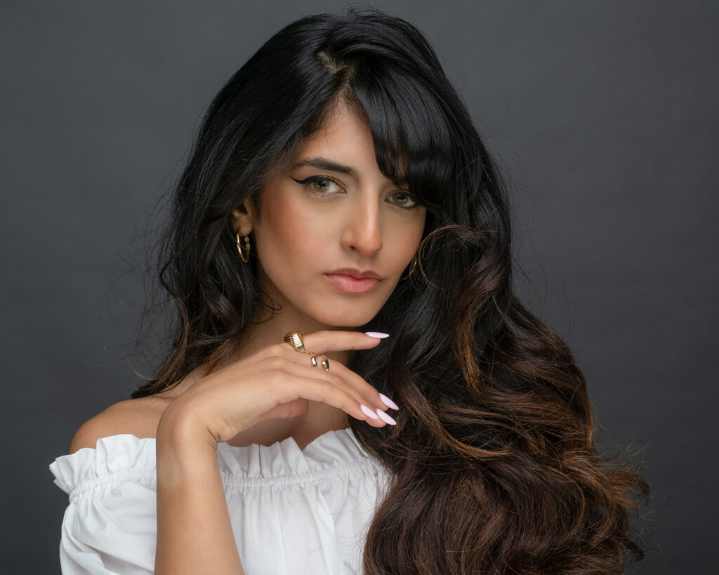 Elegant woman with long dark hair and gold jewelry, Pudsey Camera Club.