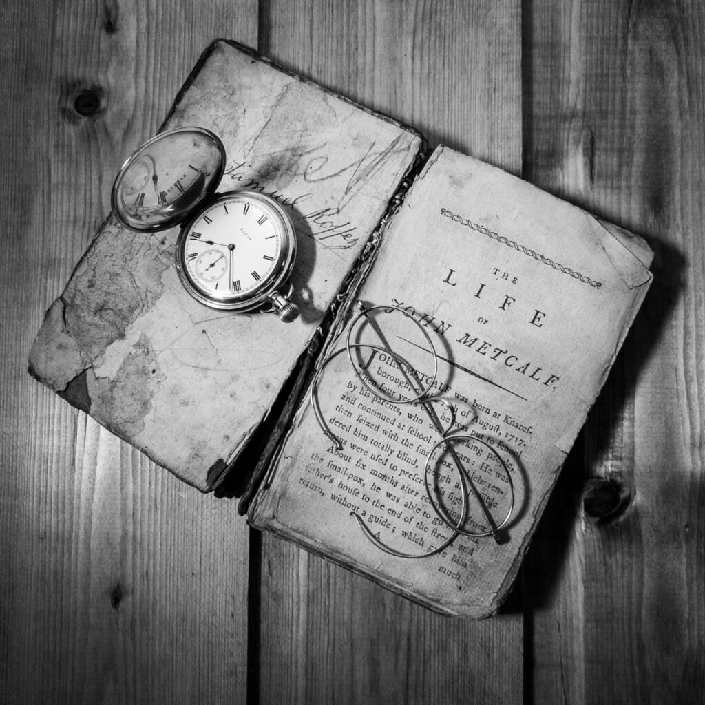 Old books, pocket watch, and glasses on wooden surface, Pudsey Camera Club.