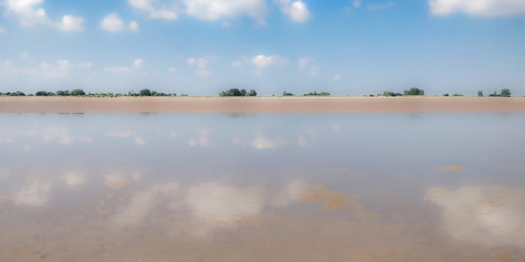 Calm lake with mirror-like reflection and blue sky, Pudsey Camera Club.