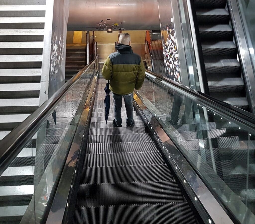 Person riding an escalator in a contemporary building Pudsey Camera Club.