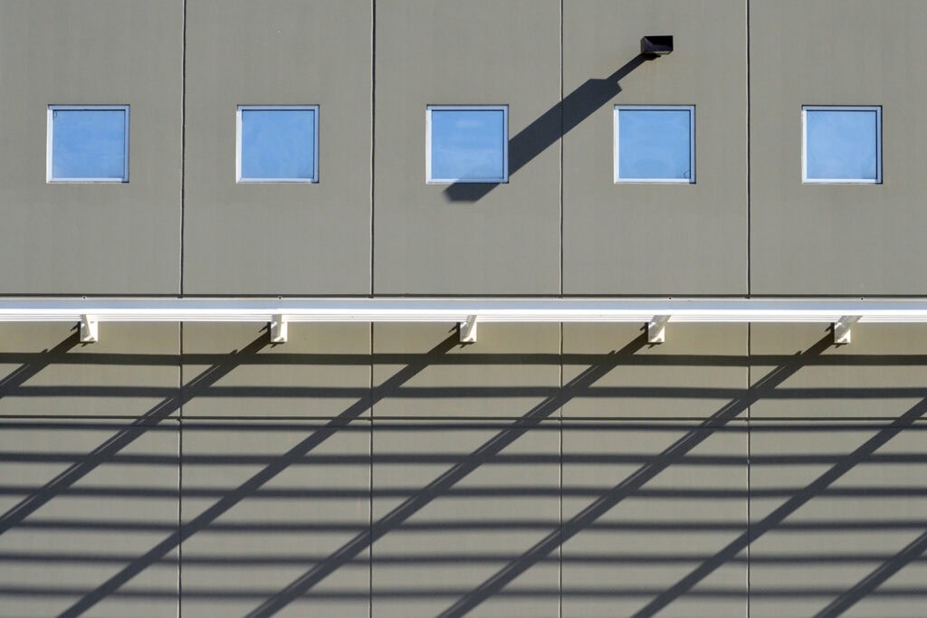 Contemporary building facade with square windows and a streetlight shadow, Pudsey Camera Club.