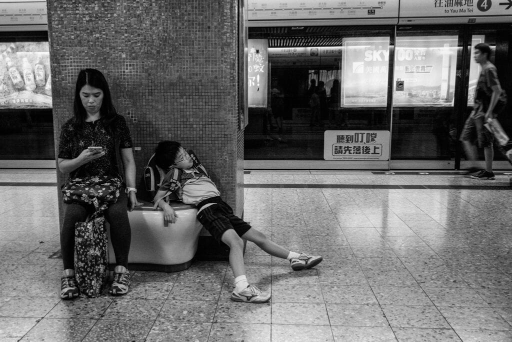 Young girl and boy sitting on a bench in a subway station at Pudsey Camera Club.